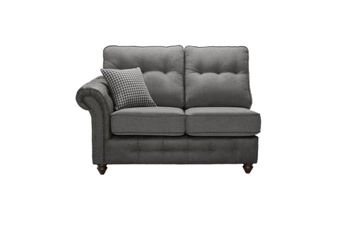 A grey two-seater sofa with a patterned cushion and studded armrest.