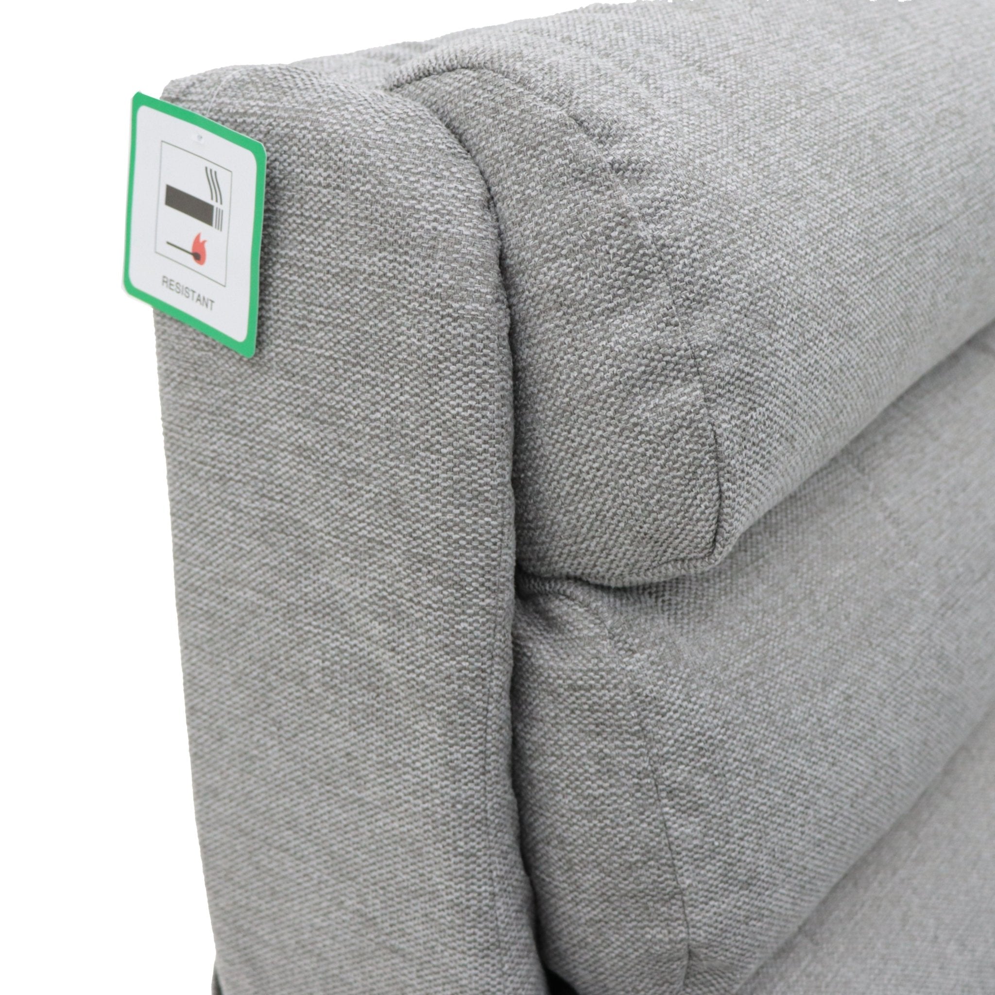 Grey fabric armchair with a fire-resistant tag.