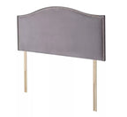 A grey fabric headboard with nailhead trim and wooden legs.