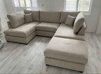 U shaped fabric corner sofa with footstool in a neutral tone.