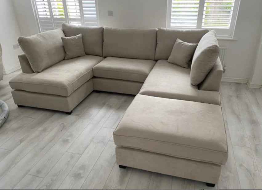 U shaped fabric corner sofa with footstool in a neutral tone.