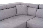 A grey fabric corner sofa with diamond-stitched back cushions and headrests.