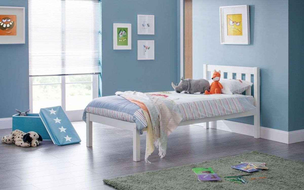 A white wooden Luna bed frame with a stuffed rhino and fox on the bedding.